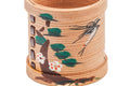 Close-up of the painted dragonfly, pine needles, and plum blossoms on the ribbed cedar.