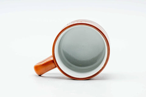 Looking down into the white-glazed interior, with the handle visible.
