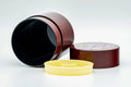 The canister opened to show the dark interior and gold inner lid, with the floral lid beside it