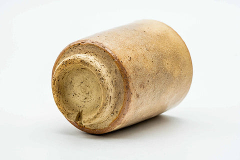 Teacup resting on its side, showing the full height of the cylindrical form.
