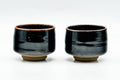 The matching pair of glossy black cups, front view.