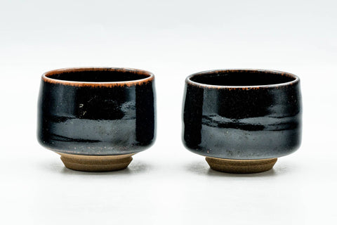 The matching pair of glossy black cups, front view.