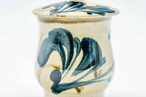 Close-up of the cup body detailing the blue-green floral brushwork, lid on.