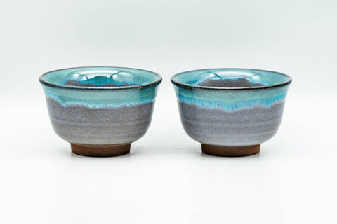 Pair of Agano-yaki teacups, front view showing blue-green dripping glaze over beige clay