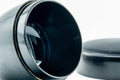 Weathered black-lacquer matcha tea caddy, angled view with lid off, showing the interior and the underside of the lid