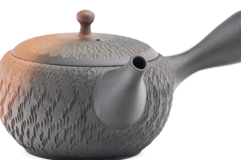 Black-and-red yōhen Tokoname kyusu teapot with side handle and dimpled tochiri texture - high-angle view of the spout and lid