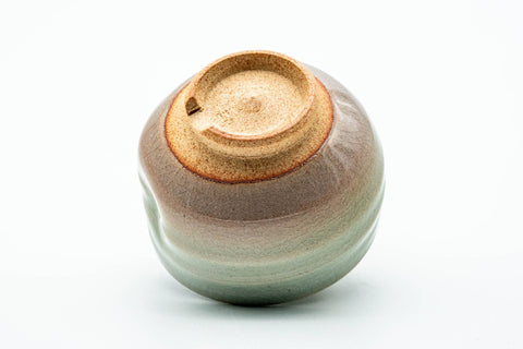 The cup tipped to show its unglazed foot and base.