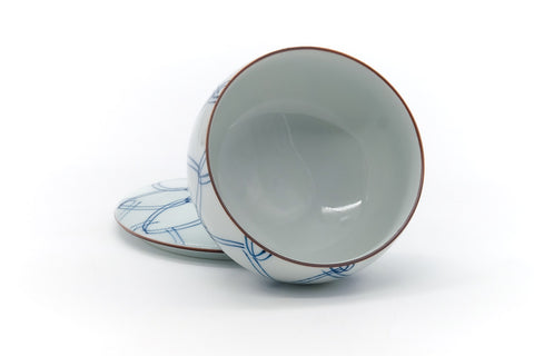 The lid removed and propped beside the tilted cup, revealing the glazed interior.