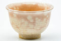 Close-up of a single yunomi showing the pink gohonte blush and Hagi glaze.