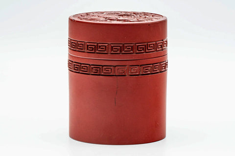 Front view of the cylindrical red lacquer tea canister with carved decoration