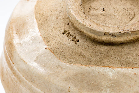 Closeup of the base showing the foot, crazing, and an impressed mark.