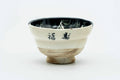 Side view of the cup, showing brushed Japanese kanji over the cream glaze.
