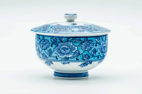 Slightly angled view of the lidded blue-floral cup.