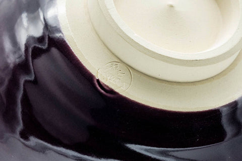 Closeup of the interior and foot showing the pale glazed base and purple wall.