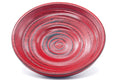 Close-up of a single red wooden chataku saucer, showing the turned concentric spiral rings and red finish