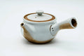 Front view of the white kyusu showing the spout, lid on.
