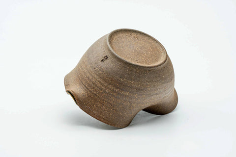 The ash-glazed katakuchi resting on its side, showing the pale exterior and base.