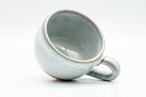 Overhead view looking into the cup's white-glazed interior and rim, handle at right.