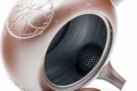 Banko-yaki kyusu with the lid lifted off, showing the dark interior and integrated strainer