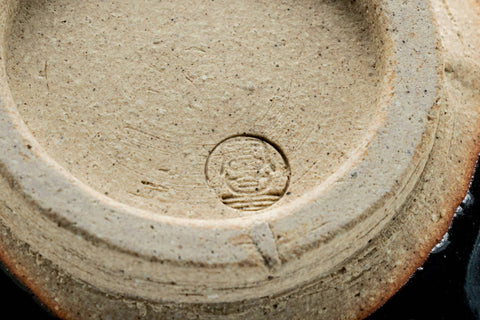 Closeup of the exposed clay foot and underside of the black chawan