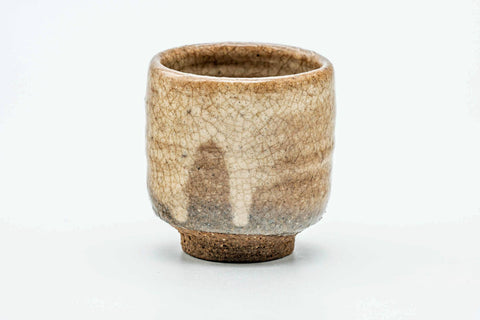 Single stone-beige guinomi teacup with a mottled matte glaze, front view.