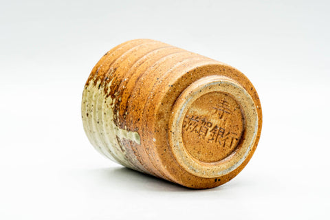 Tilted view of the Shigaraki yunomi on its side, showing the lower body and recessed unglazed foot