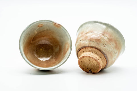 One cup tilted to show the glazed interior beside the other cup, revealing the foot.
