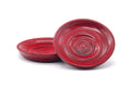 Pair of red wooden chataku (tea saucers) with concentric spiral grain, shown together with one tilted to show the dished form