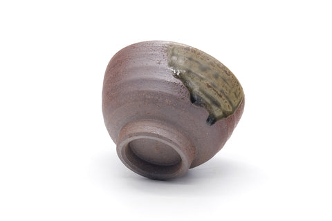 Cup tilted to show the rim and the green ash glaze near the top.