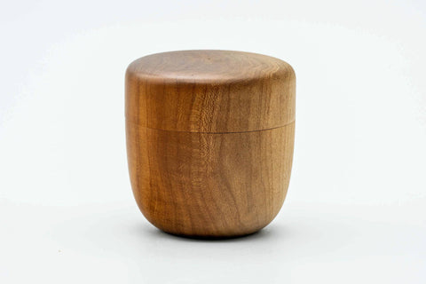 Three-quarter view of the closed wooden canister.