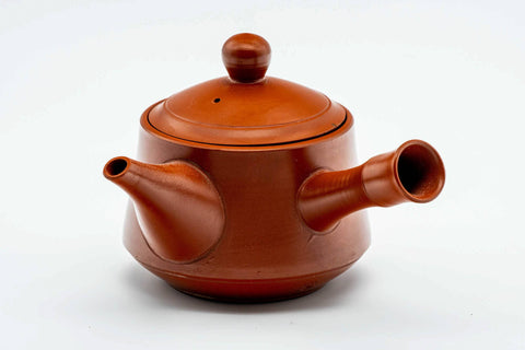 Rear three-quarter view of the red kyusu showing the bamboo-shaped handle.