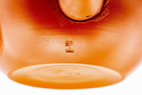 Underside of the wide red kyusu showing the foot and maker's mark.