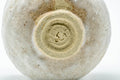 Close view of the foot and lower body showing the carved foot ring and milky glaze.