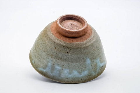The bowl tipped to reveal its carved foot (kodai) in red clay.