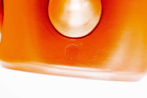 Closeup of the glossy red shudei body and base of the Tokoname kyusu