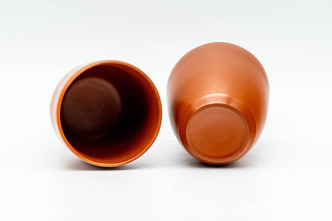 The two teacups, one upright and one inverted to show the unglazed foot and base.