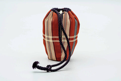 The accompanying shifuku, a red tartan-patterned brocade drawstring pouch.