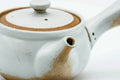 Side view showing the spout and the contrast between the white glaze and brown clay.