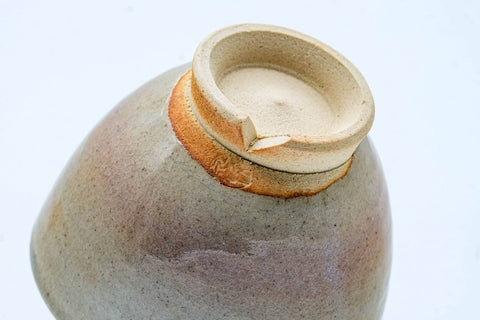A cup tipped to show its unglazed foot and base.