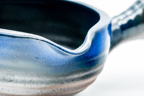 Close-up angled into the spout, showing the blue glaze pooling at the lip.