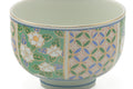 Closeup of the side of the yunomi detailing the green floral and blue geometric lattice pattern