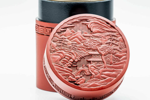 Close-up of the carved village landscape scene on the lid