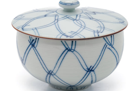 Close-up of the lidded cup showing the blue lattice design and brown-edged rim.