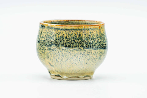 Side view of the green-and-yellow drip-glazed cup.