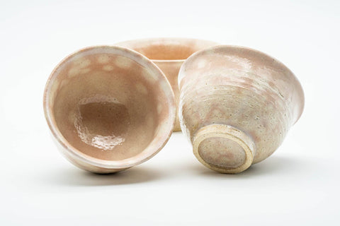 Two cups tipped to reveal the glazed interior and unglazed foot.