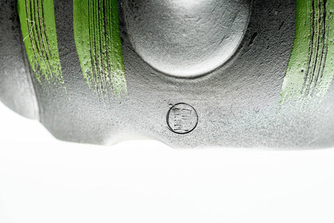 Top-down close-up of the lid knob and green stripes.