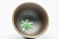 Close-up of a cup's interior, showing the green leaf decoration.