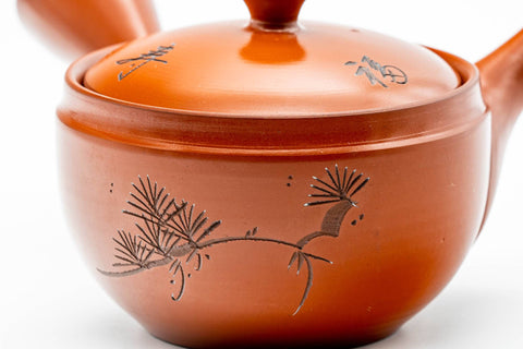 Close-up of the engraved kanji and leaf motifs on the red shudei body.
