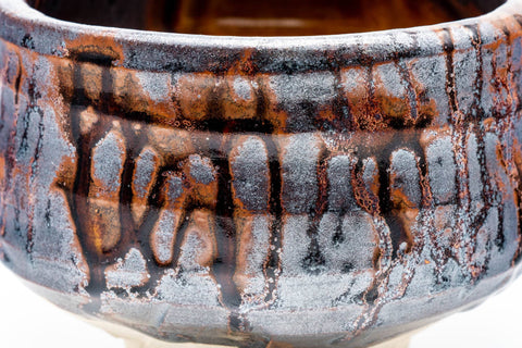 Close-up of the dripping metallic glaze texture on the exterior