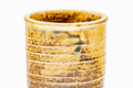 Close-up of a cup, showing the brown-and-yellow drip glaze.